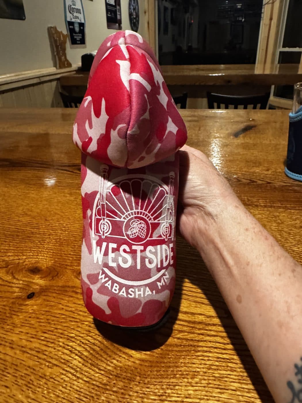 Hooded Bottle Koozie, Pink Camo: Zip-up hoodie bottle koozie with the WESTSIDE crest.